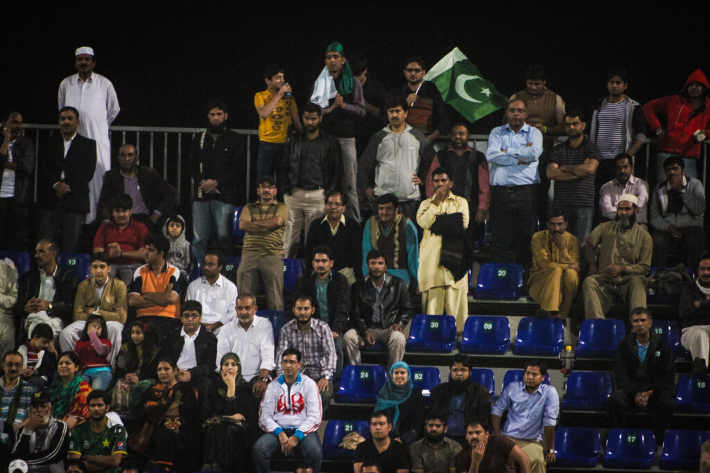 Pakistan fans in stadium stands waving the Pakistan flag