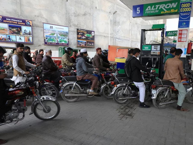 Motorcyclists refuelling at a petrol station in Pakistan