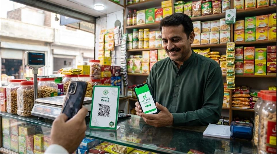 JazzCash Raast QR Merchants Hit 1.9 Million as Cashless Pakistan Push Accelerates 3 Pakistani shopkeeper showing Raast QR payment standee at a karyana store counter