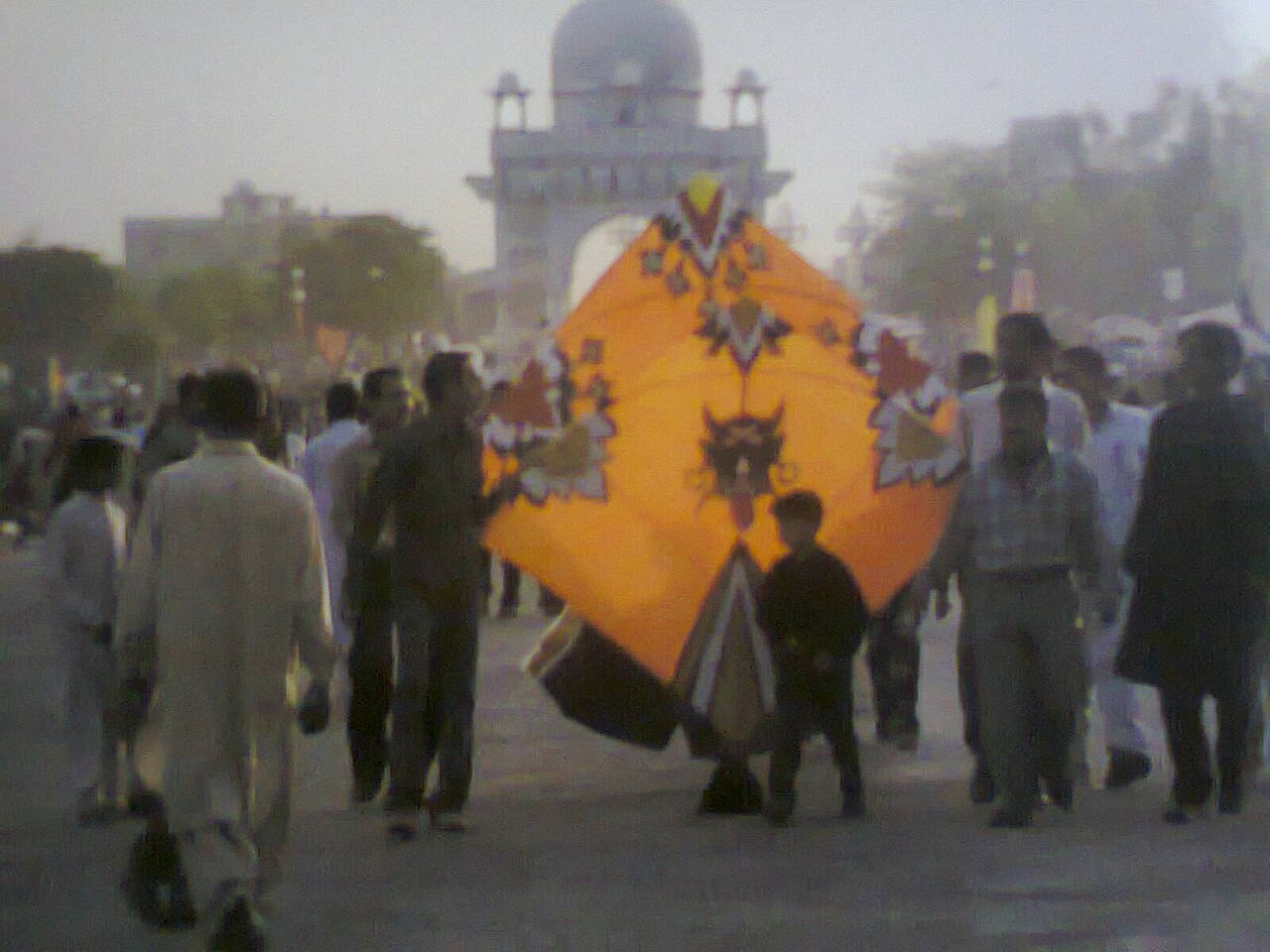 Basant kite fliers holding a large decorated kite at the festival in Pakistan