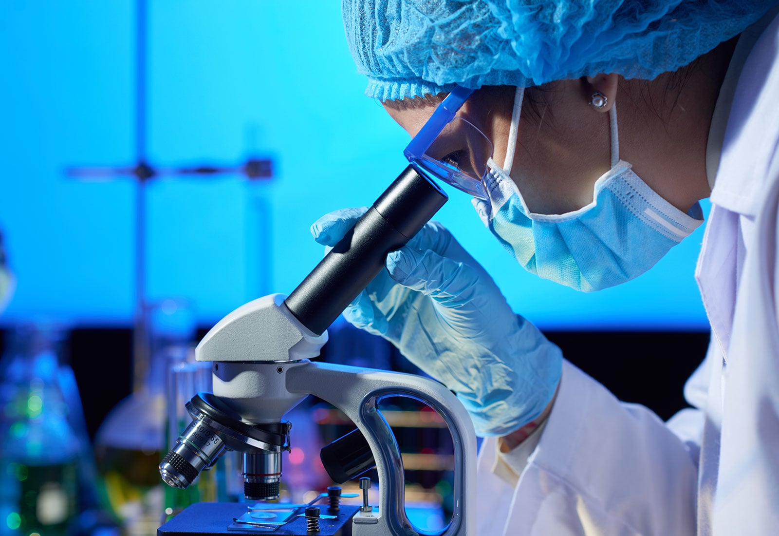 Clinician examining a blood sample under a microscope
